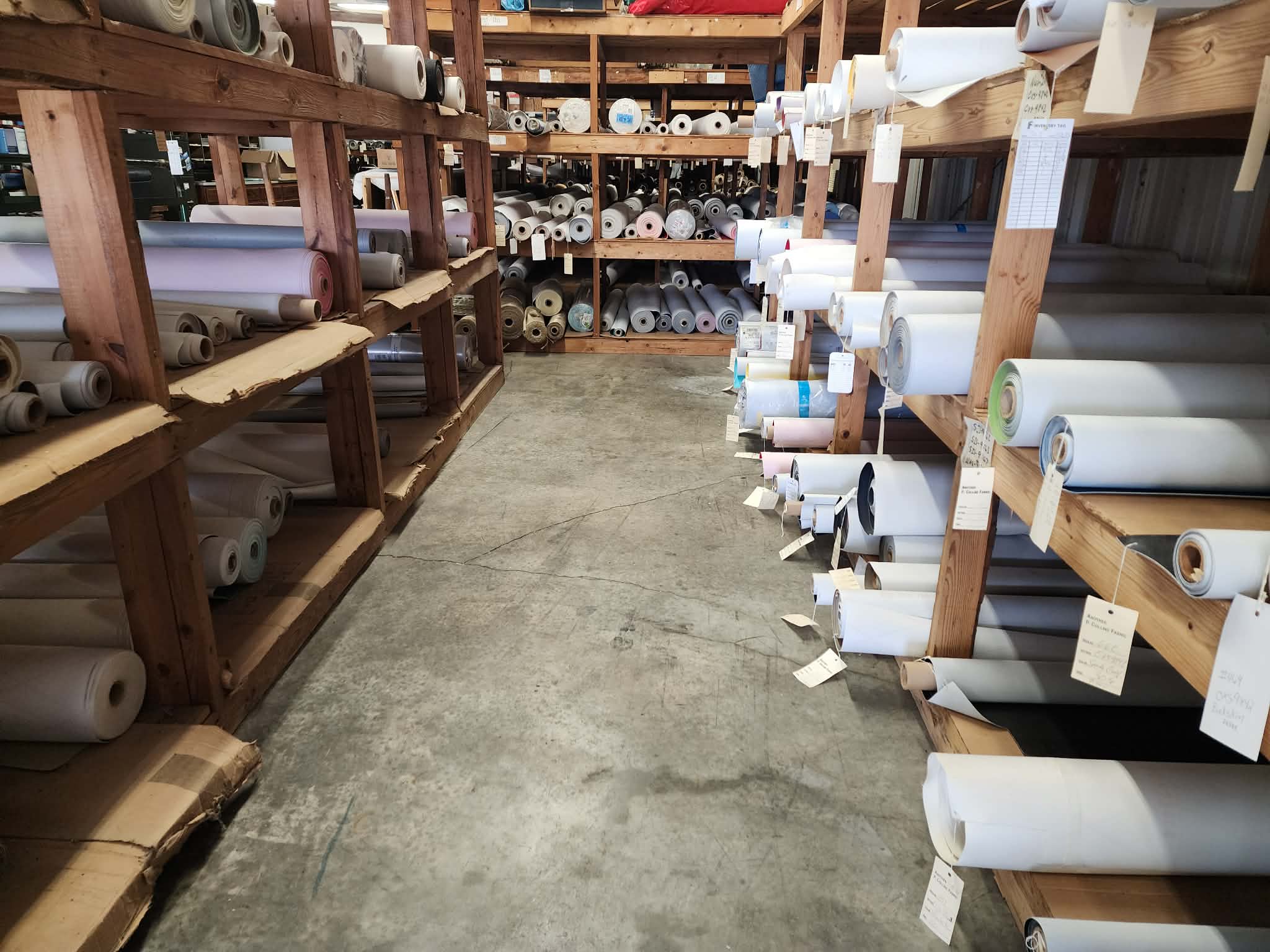 Rows of upholstery vinyl and fabric in stock at Carolyn Fabrics