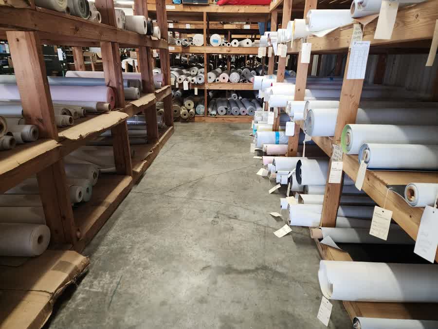 Rows of upholstery vinyl and fabric in stock at Carolyn Fabrics